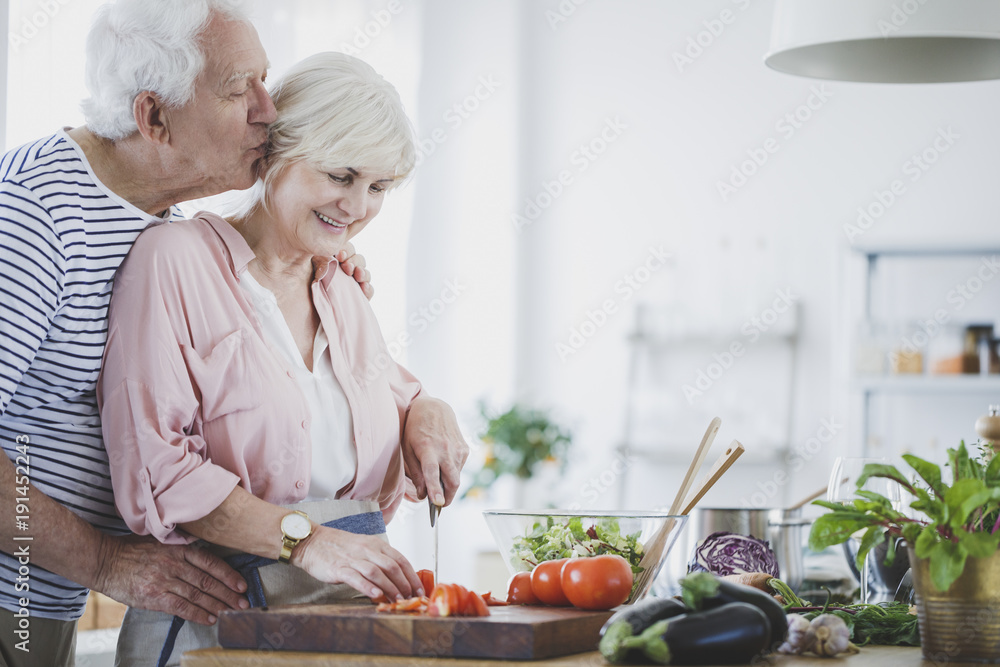 Elderly man kissing wife Elderly man kissing wife