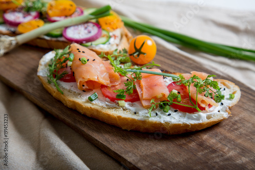 Healthy and tasty toast bread with tomato, radish, salmon fish and cheese on it.