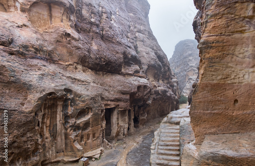 Tombs and stone stairs at heavy rain in Little Petra - ancient Nabatean city. Jordan © vadiml