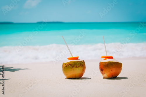 two coconut drinks on tropical beach vacation