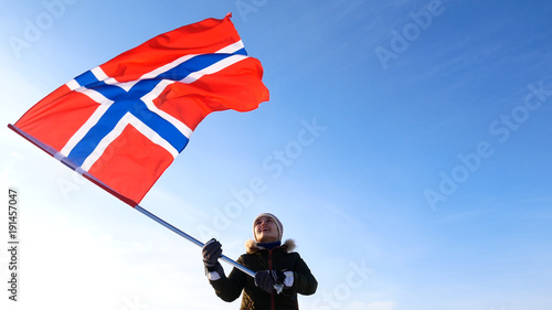Woman with norway flag on the top point. Succesful winer consept