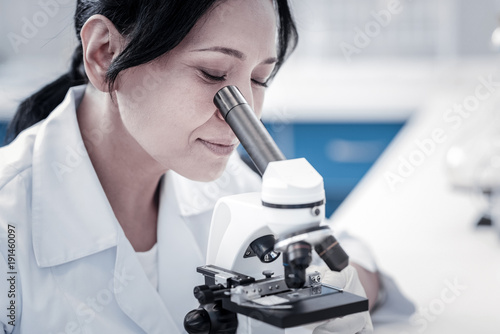 Laboratory testing. Close up of a beautiful female scientist working in a laboratory and analyzing a microscope slide during a medical experiment.