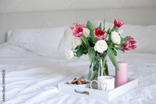 Fototapeta Naklejka Na Ścianę i Meble -  Romantic breakfast in bed. Bouquet of flowers. Roses and tulips. Spring. Valentine's Day. International Women's Day. Cozy.