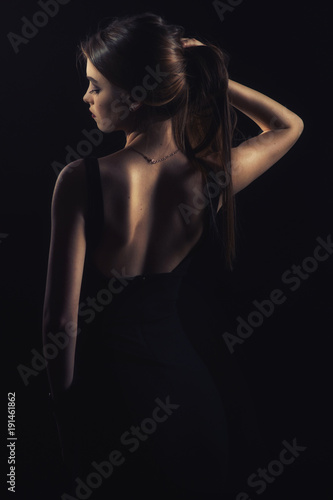  slim slim girl in dress with neckline in glamorous light from back © Антон Фрунзе