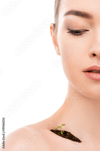 beautiful girl with soil and sprout on collarbone, isolated on white