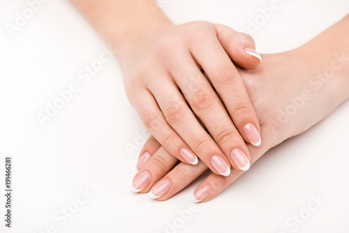 cropped view of female hands with natural manicure, isolated on white