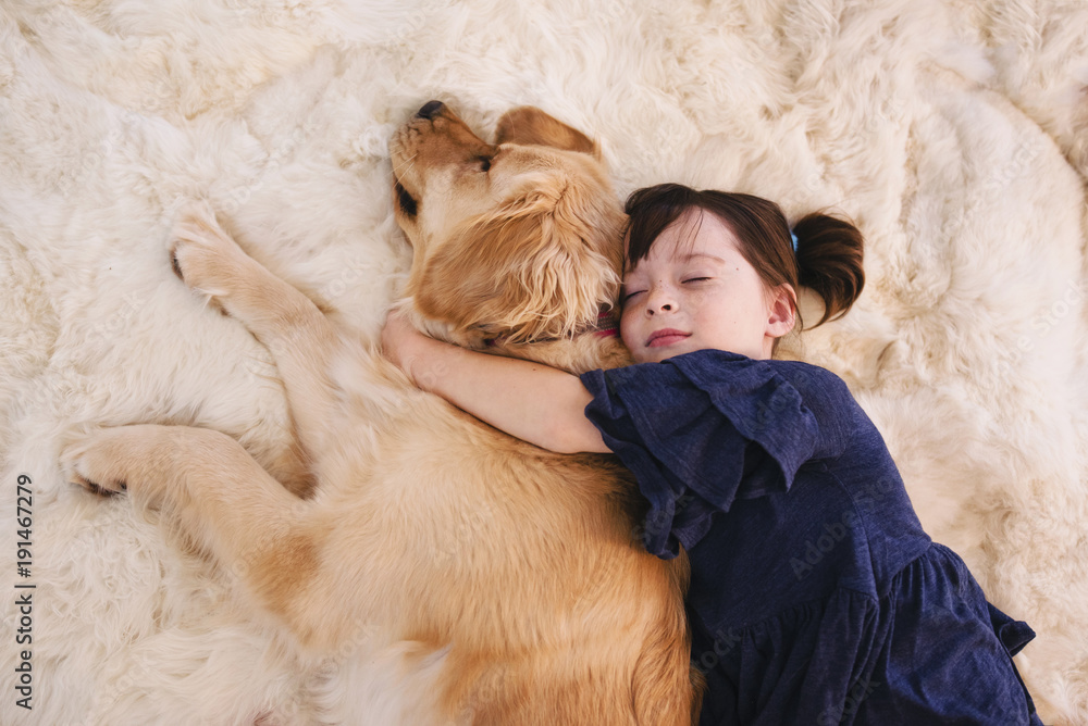 Girl sleeping on a rug with her golden retriever dog Stock Photo ...