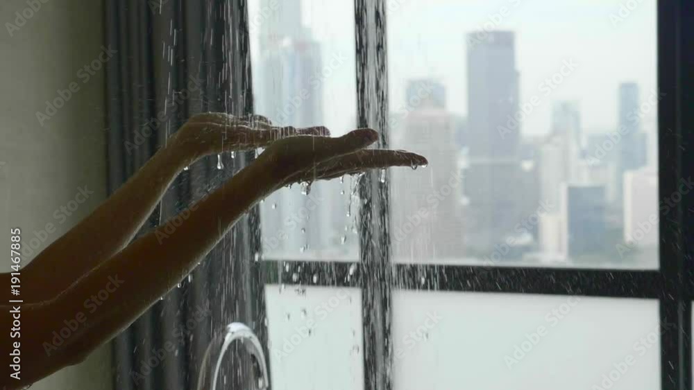 Slow motion shot of shower water stream on woman hands in bathroom with window. Slow motion shot of shower water stream on woman hands in bathroom with window.