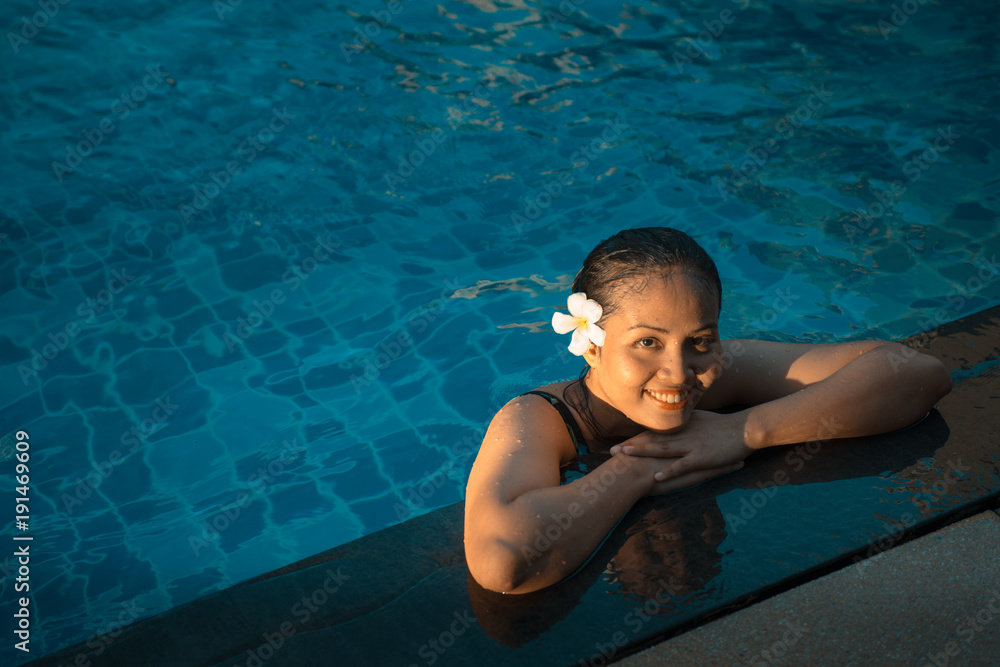 Smiling portrait of beautiful woman in swimming pool,Beautiful young woman relaxing in spa swimming pool.
