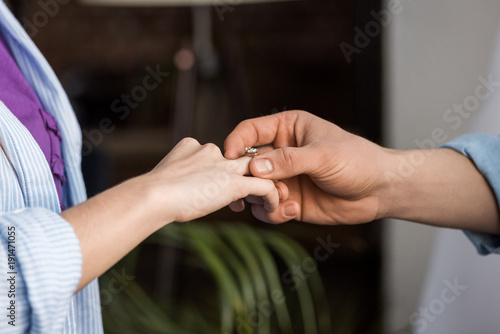 cropped image of boyfriend proposing girlfriend and wearing engagement ring