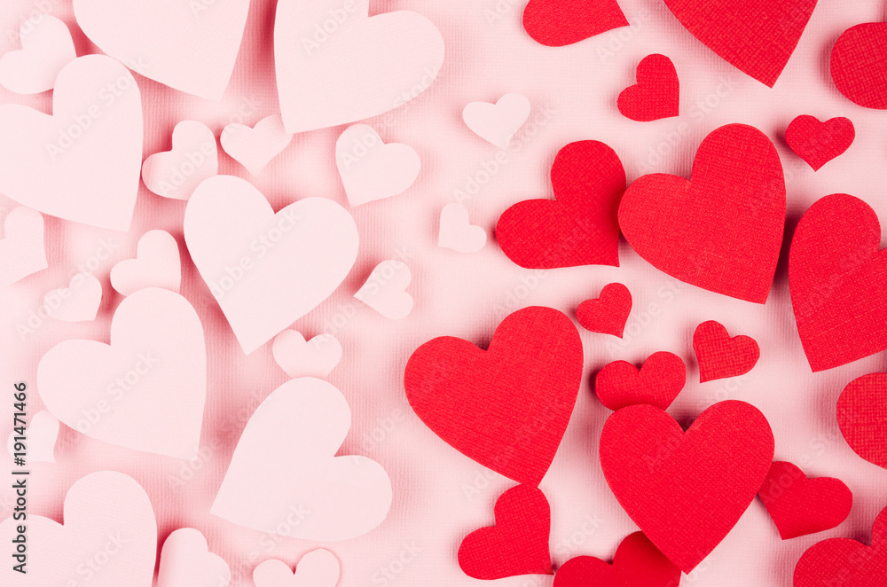 Valentine day background. Stream of fly paper red and pink hearts on pink color backdrop.