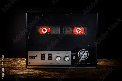 Tape recorder on wooden table with black background