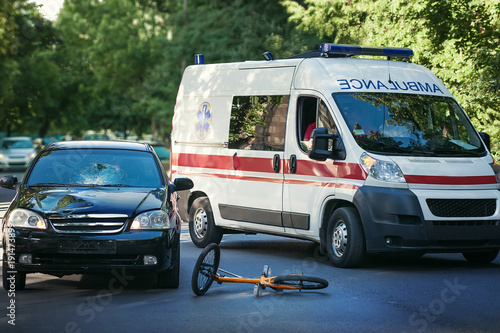 Accident on the road. The car hit a bicyclist. The ambulance takes the victim