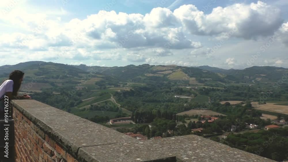 Young girl staring at a beautiful landscape from an old balcony of a castle. Young girl staring at a beautiful landscape from an old balcony of a castle.
