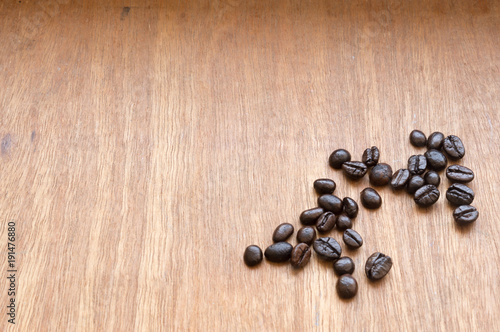 Roasted coffee beans scattered on red-grey wooden background