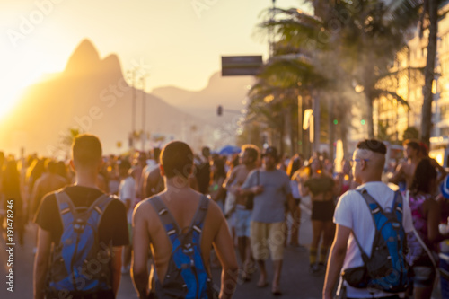 Abstract blur view of young unidentifiable brazilians celebrating carnival at a sunset bloco street party on the Ipanema beachfront.  photo
