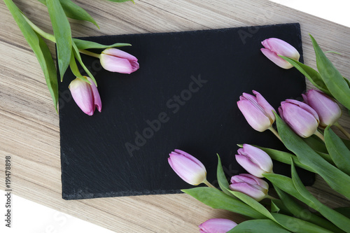 Fototapeta Naklejka Na Ścianę i Meble -  bunte tulpen auf schwarzer schiefersteinplatte