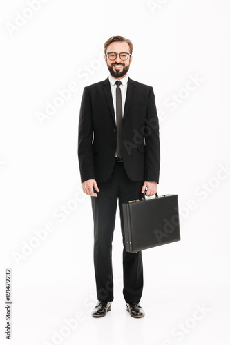 Konstfotografi Full-length image of good-looking man in business suit posing with black briefca