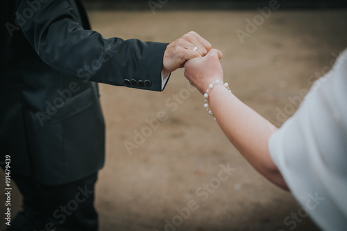 bride and groom holding hands while they are walking