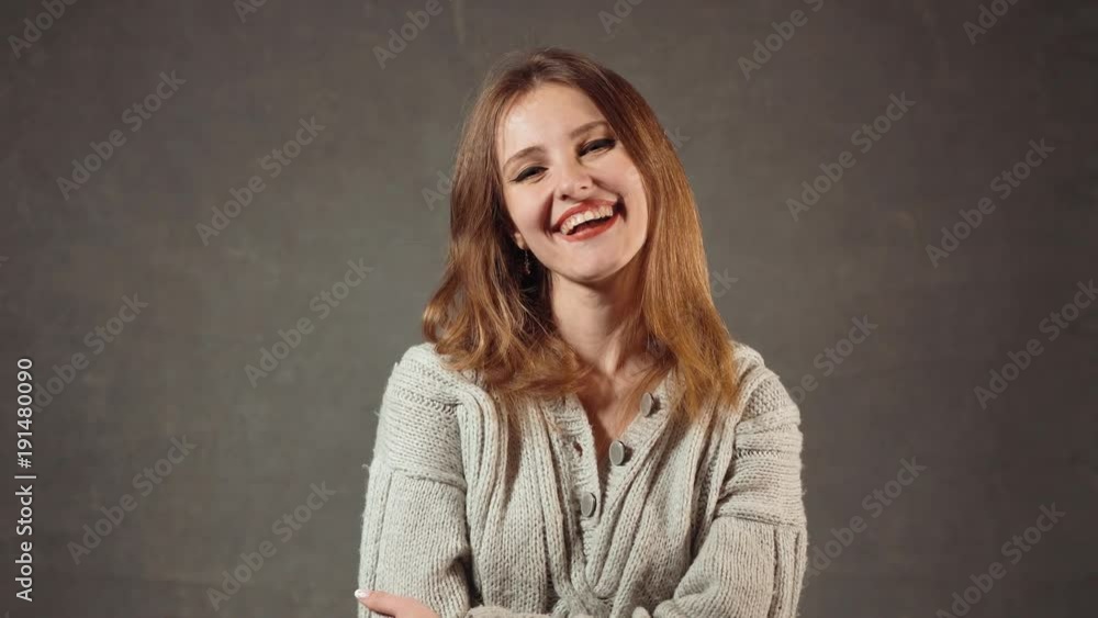 Portrait of smiling caucasian beauty, long-haired girl posing joyfully in the gray background Portrait of smiling caucasian beauty, long-haired girl posing joyfully in the gray background