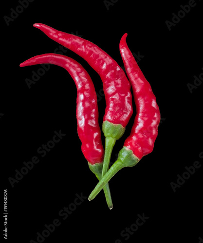 3 beautiful red chili peppers flame-shaped on black background