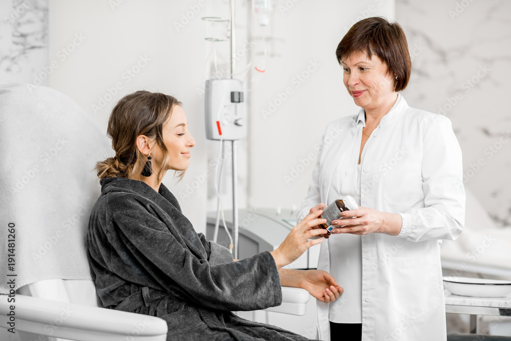 Obraz premium Senior doctor offering bio additives to a young patient in the medical resort