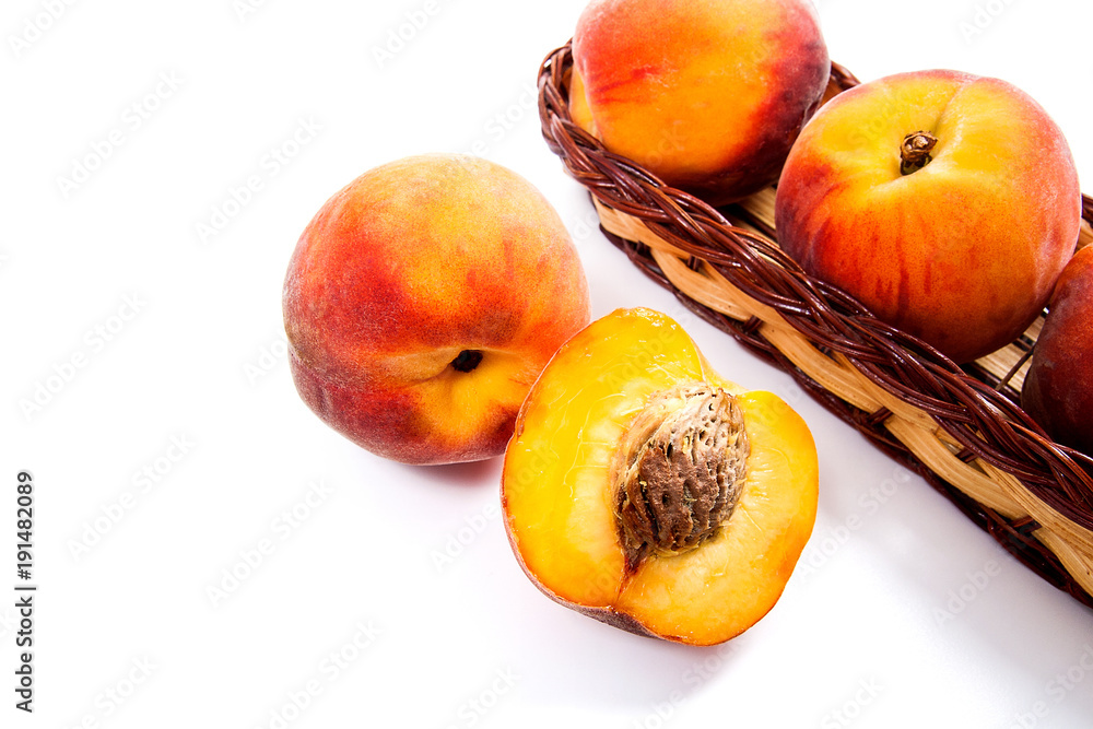 Whole and half of ripe peach fruit and several in basket isolated on white background. Whole and half of ripe peach fruit and several in basket isolated on white background.