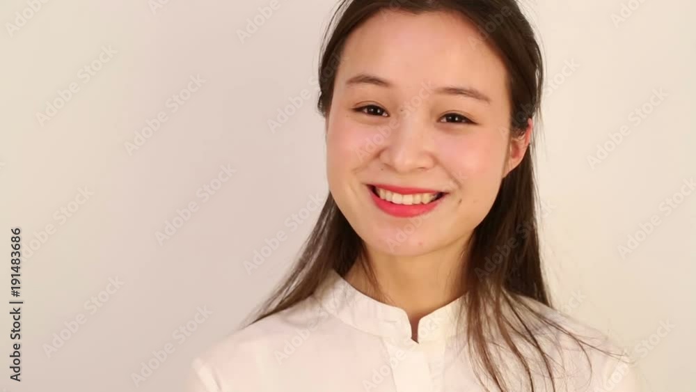 Young woman with a lovely smile and close up head shot over a white background Young woman with a lovely smile and close up head shot over a white background
