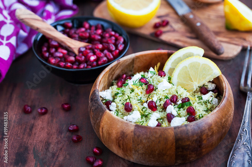 Delicious healthy cous cous salad with herbs, lemon zest, feta cheese and pomegranate seeds