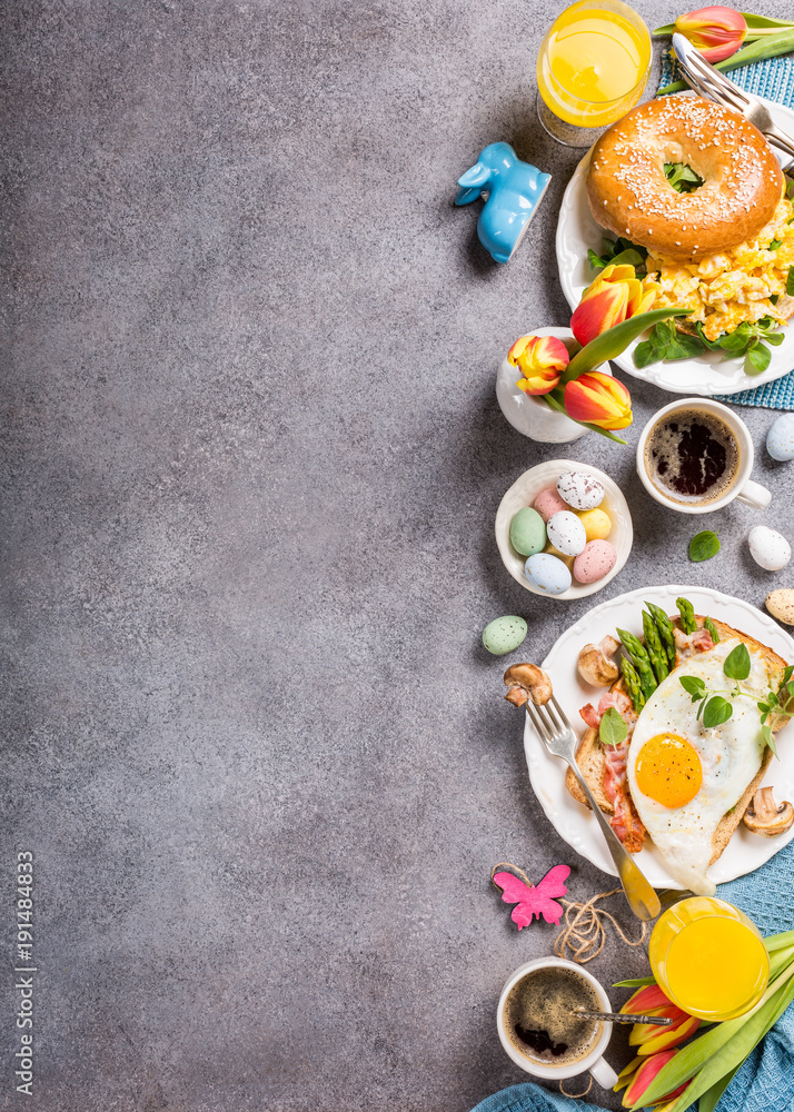 Wall Mural Easter breakfast flat lay with scrambled eggs bagels, orange tulips, bread toast with fried egg and green asparagus, colored quail eggs and spring holidays decorations