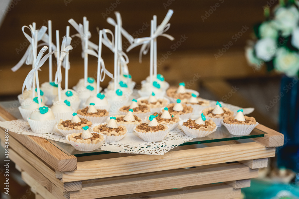rows of birthday cupcake with butter white and blue cream icing on a wooden stand rows of birthday cupcake with butter white and blue cream icing on a wooden stand