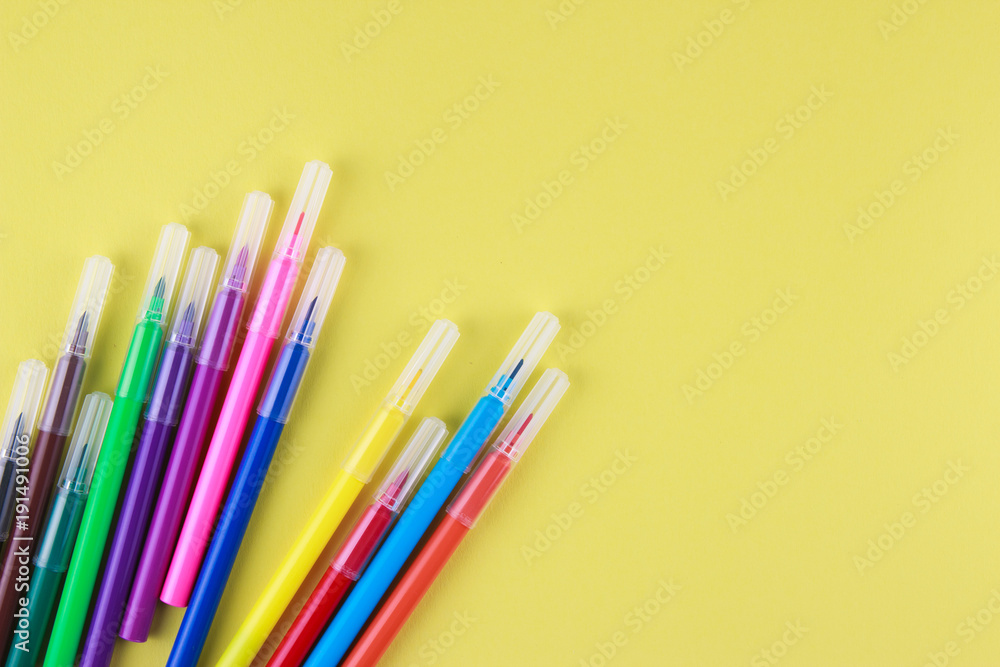 Colored pens on a yellow background Colored pens on a yellow background