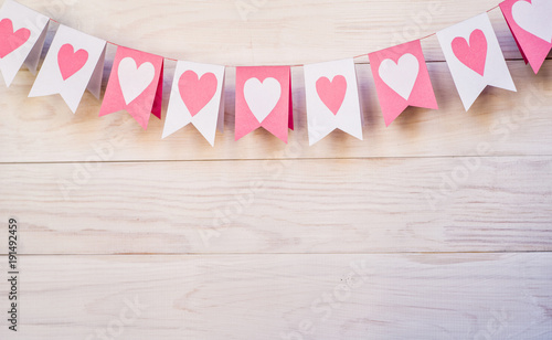 valentine day concept. white and pink flags hangingon a rope on white rustic background