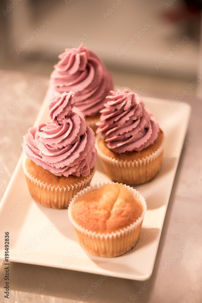 close up view of sweet cupcakes on plate on counter in restaurant kitchen