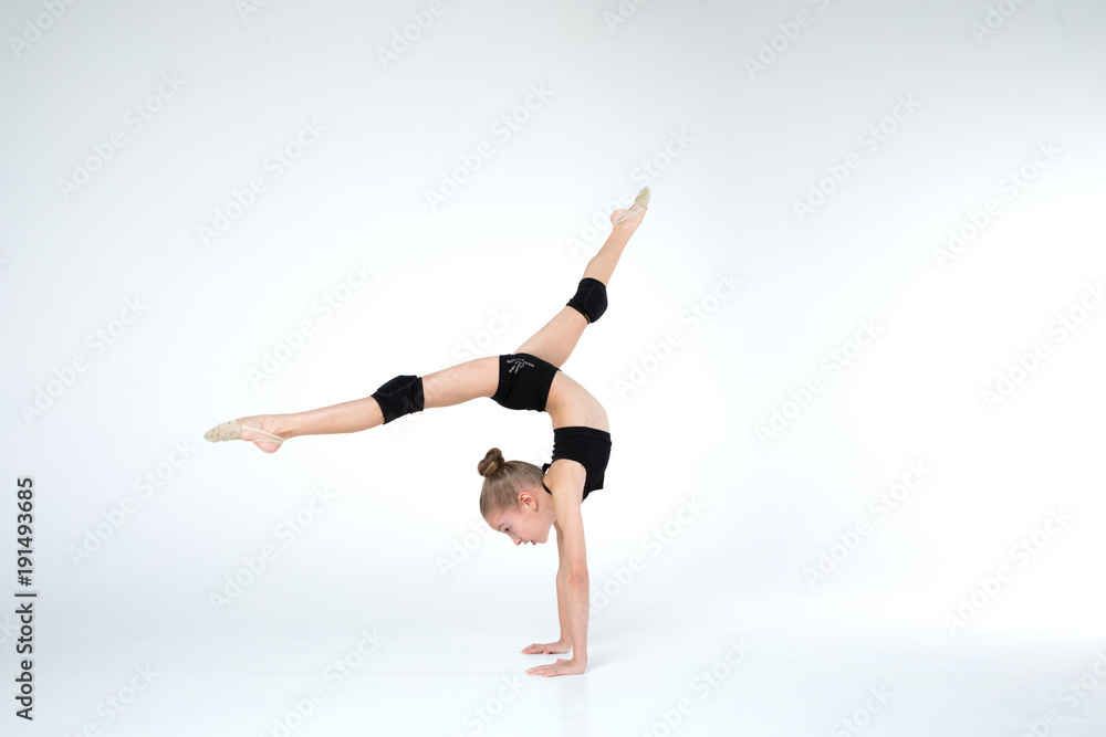 Rhythmic gymnastics caucasian ballet dancer girl in black suite stretching in black costume on white background isolated showing flexible fitness Rhythmic gymnastics caucasian ballet dancer girl in black suite stretching in black costume on white background isolated showing flexible fitness