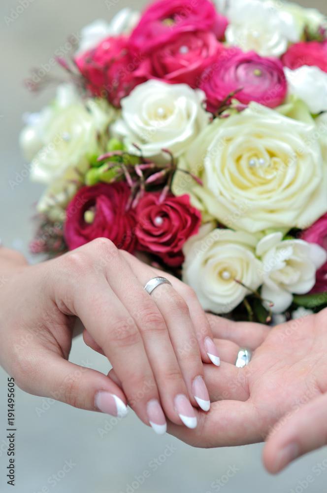 the hands of young married couples and the wedding bouquet the hands of young married couples and the wedding bouquet
