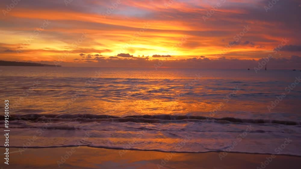 Calm tropical waves hitting shore on perfect Asian sunset Calm tropical waves hitting shore on perfect Asian sunset