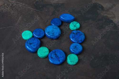 Decorative blue stones shaped heart on a dark background photo