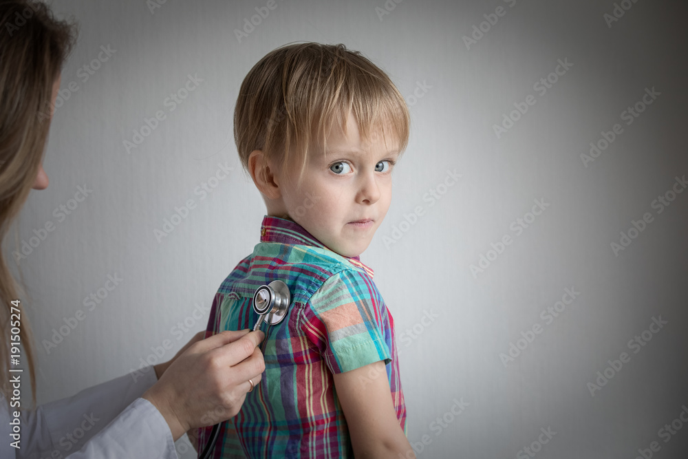 little boy at the doctor, female using stethoscope. little boy at the doctor, female using stethoscope.