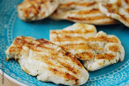 Fresh chicken fillet grilled in a blue plate 