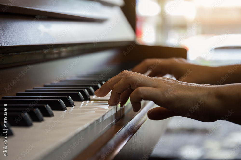 Obraz premium Close up of happy woman's hand playing the piano in the morning.