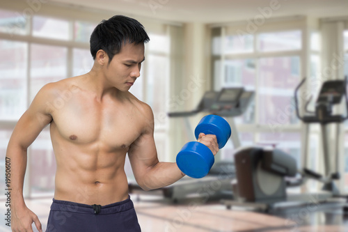 Asian man lifting dumbbell in gym