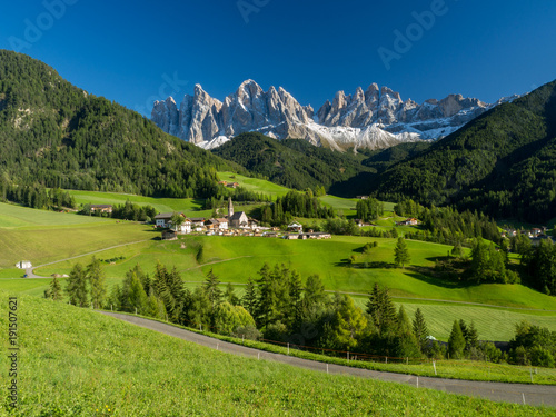 Val di Funes valley, Santa Maddalena touristic village, Dolomites, Italy, Europe. September, 2017. Green grass and blue sky.