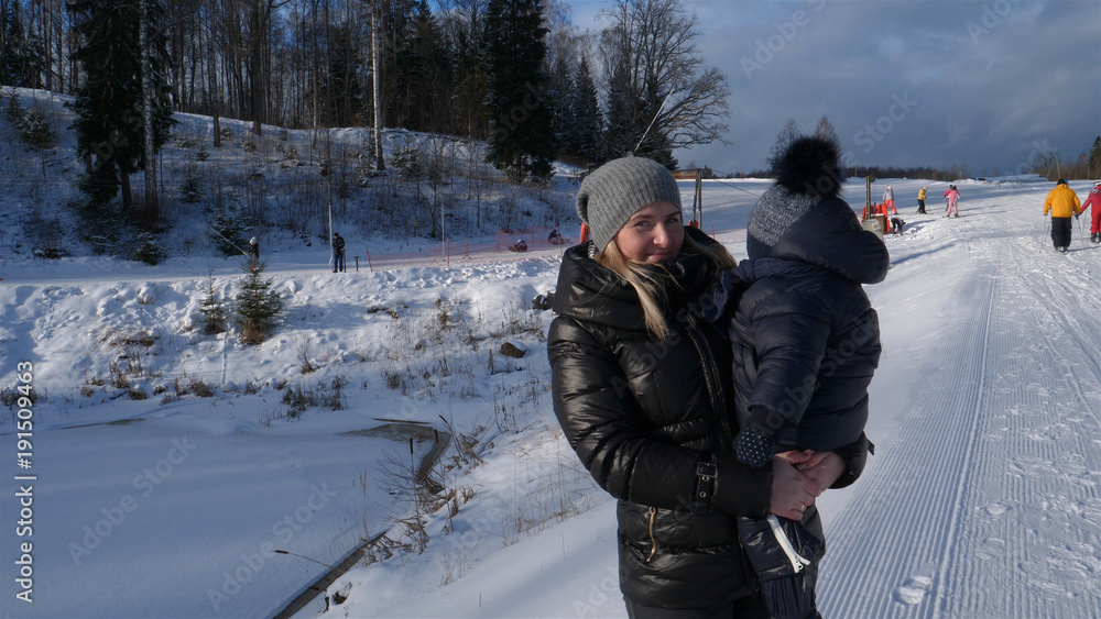 A happy beautiful mother is hugging with her baby (boy, son) in a ski resort, on a sunny day, in winter, all in the snow. A happy beautiful mother is hugging with her baby (boy, son) in a ski resort, on a sunny day, in winter, all in the snow.