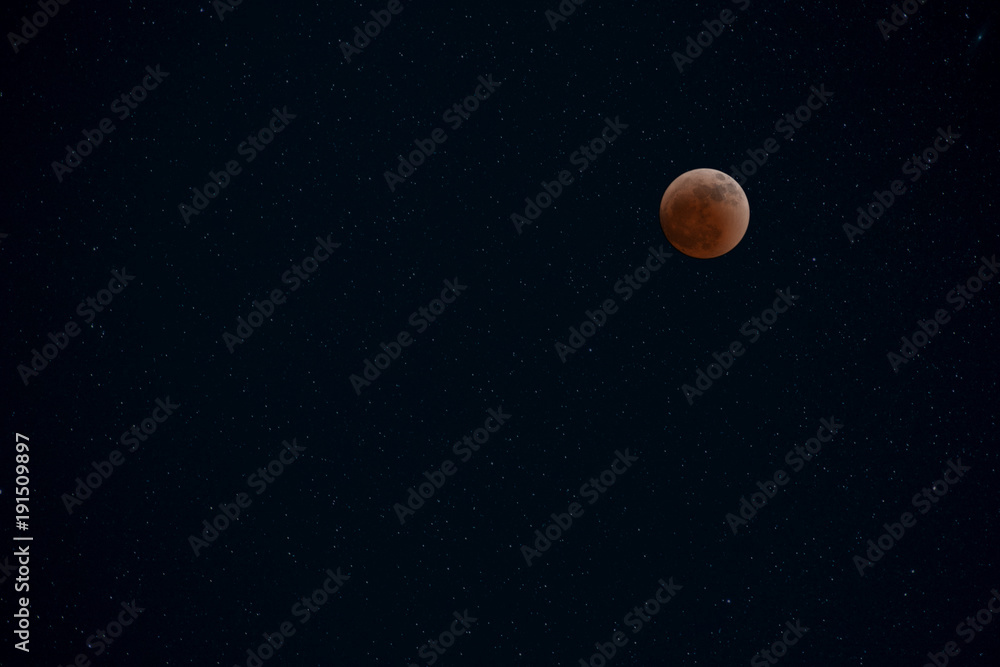 ull red eclipse moon in clear night sky with shiny stars for background