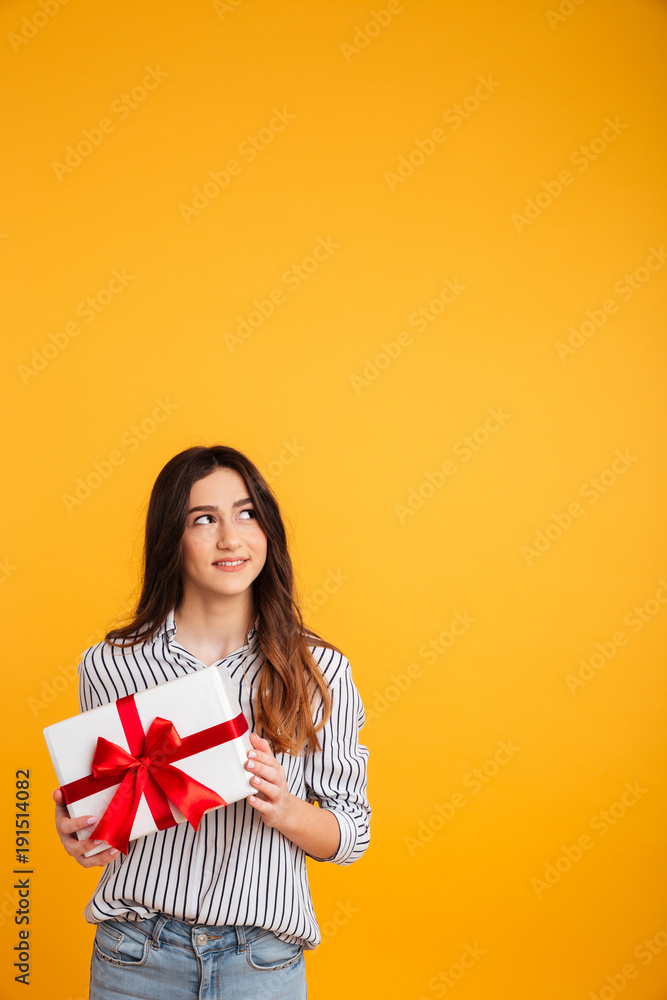 Vertical image of Smiling woman in shirt holding gift box Vertical image of Smiling woman in shirt holding gift box