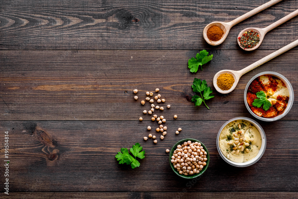 Cook chickpeas. Make hummus. Bowls with grains and ready meal near spices on dark wooden background top view copy space Cook chickpeas. Make hummus. Bowls with grains and ready meal near spices on dark wooden background top view copy space