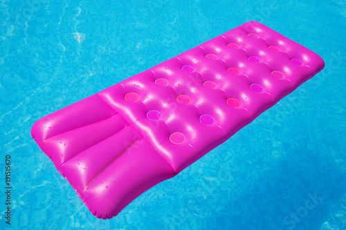 Pink air mattress on a swimming pool tropical