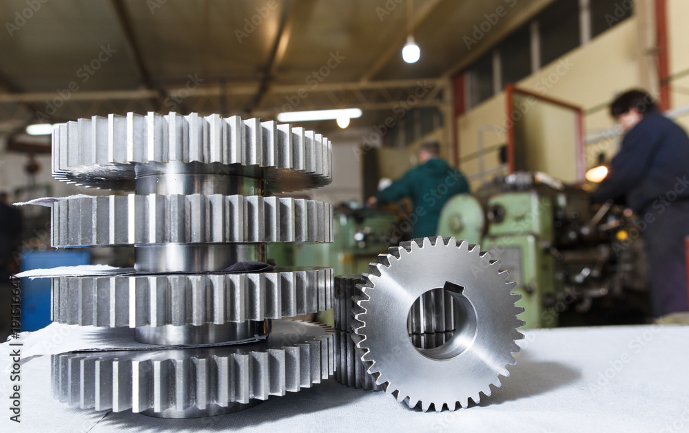 Group of new cogwheels with workshop in background. Group of new cogwheels with workshop in background.