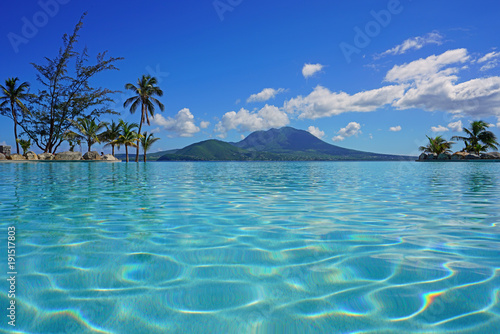 Canvas-taulu View of the Nevis Peak volcano from a swimming pool in Christopher Harbour, St K